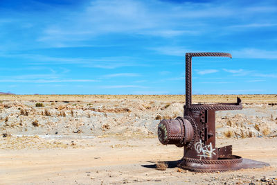 Abandoned metallic object on barren landscape