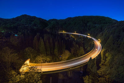 High angle view of light trails on road against sky at night