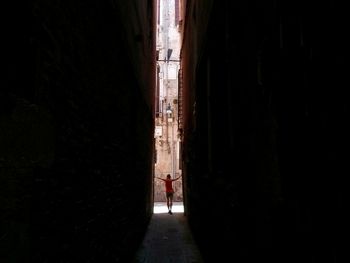 Rear view of people walking in alley