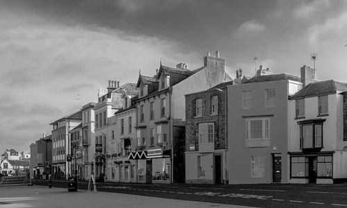 Residential buildings by street against sky