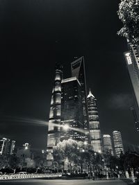 Low angle view of illuminated buildings against sky at night