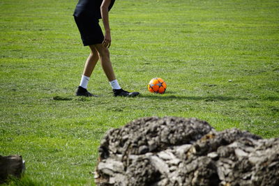 Low section of man playing soccer on field