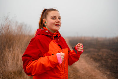 Portrait of young woman standing against sky