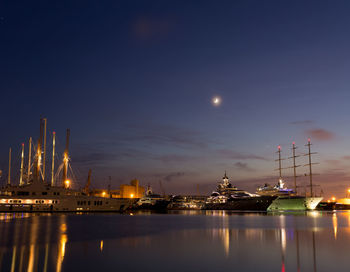 Illuminated harbor against sky at night