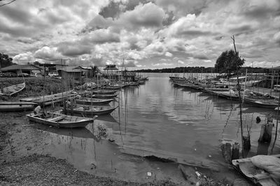 Boats moored in harbor against sky