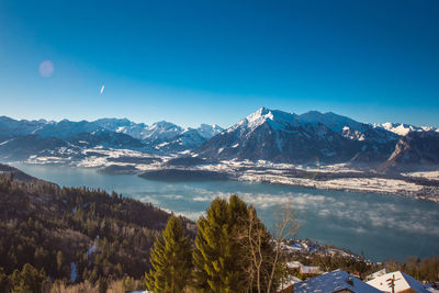 Scenic view of snowcapped mountains against blue sky