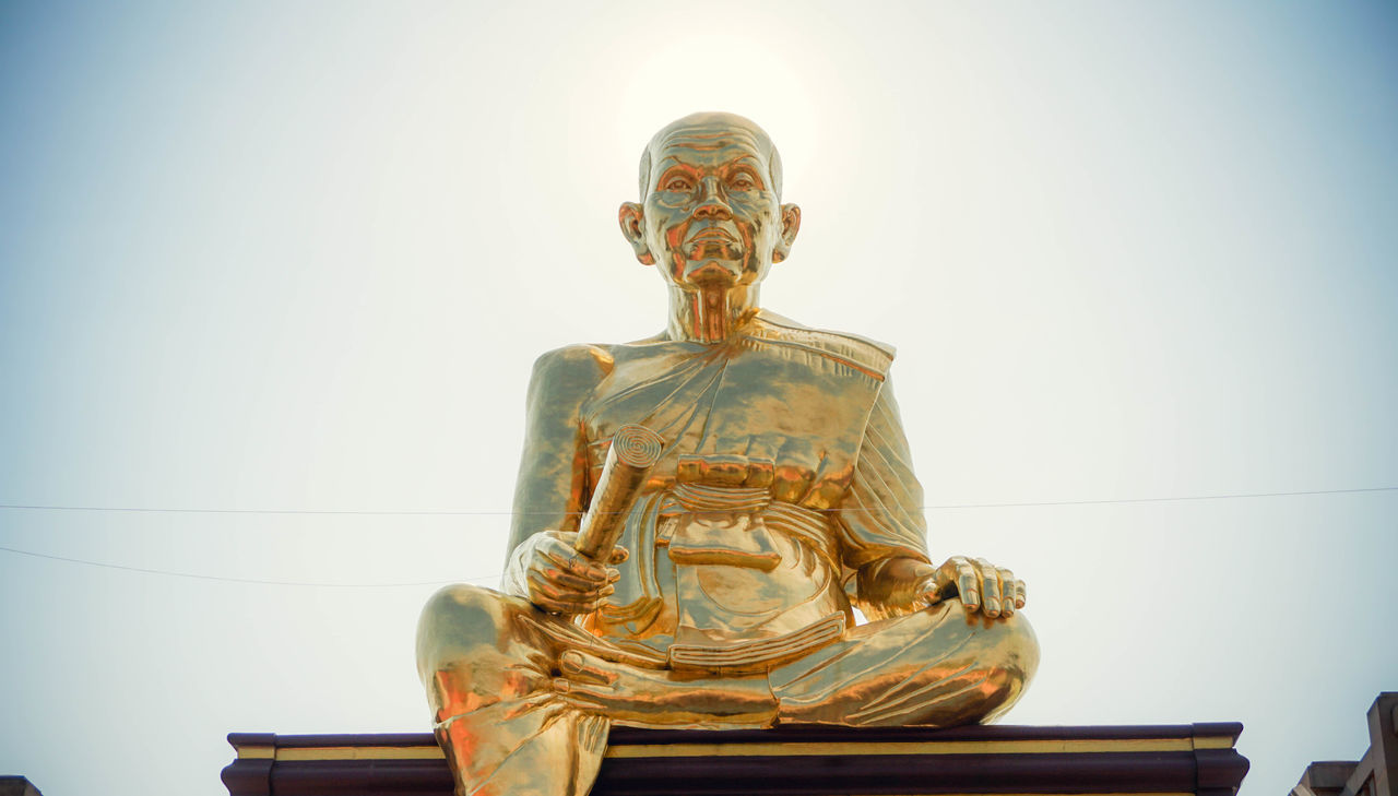 LOW ANGLE VIEW OF STATUE AGAINST TEMPLE AGAINST CLEAR SKY AGAINST BLUE BACKGROUND