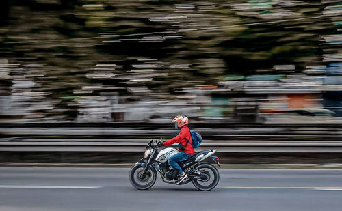 Man riding bicycle on road in city