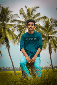 Portrait of young man with palm trees