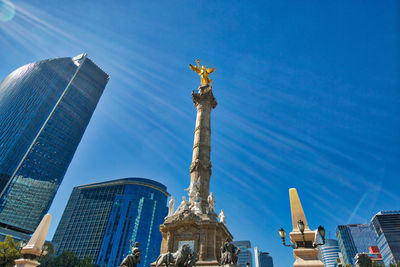 Low angle view of statue against buildings in city