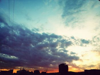 Low angle view of buildings against cloudy sky