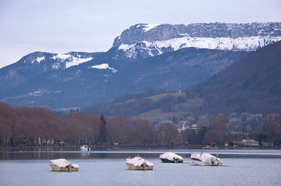 Scenic view of lake by snowcapped mountains against sky