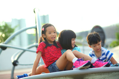 Cute friends playing on outdoor play equipment in playground