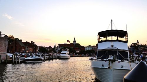 Boats in river at sunset