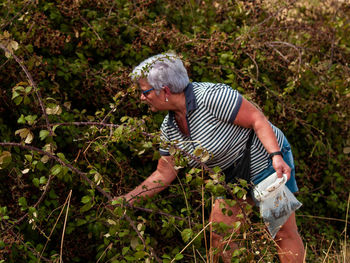 Senior woman gardening on field