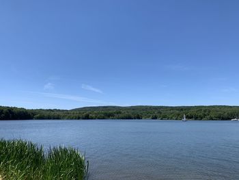 Scenic view of lake against blue sky