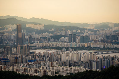 Aerial view of buildings in city against clear sky