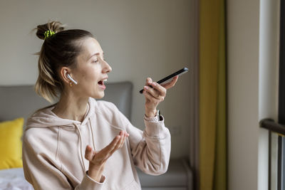 Woman talking on phone while sitting at home