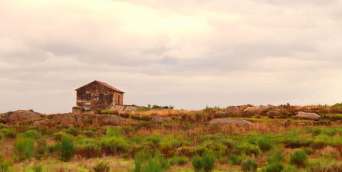 Abandoned building on field against sky