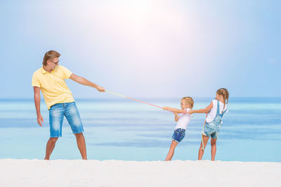 Full length of boys on beach against sky