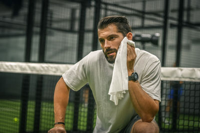 Man wipes the sweat after a training session. young sporty boy at the end the match. sweaty athlete