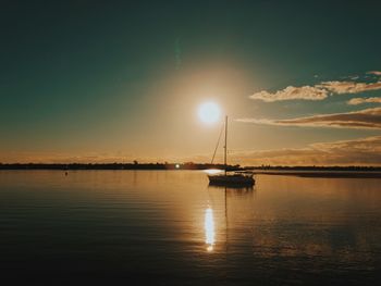 Sailboat on sea against sky during sunset