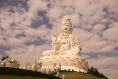 Low angle view of statue against temple against sky