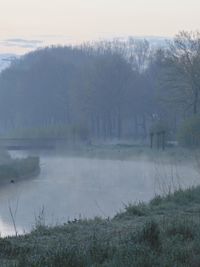 Scenic view of lake in foggy weather