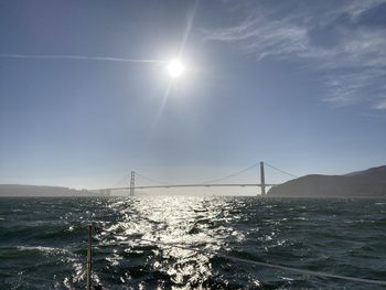Suspension bridge over sea against sky