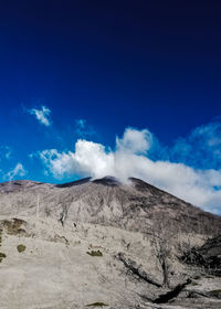 Scenic view of volcanic landscape against blue sky
