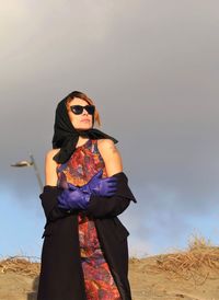 Young woman wearing sunglasses standing on land