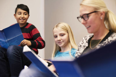 Students and teacher reading books in classroom