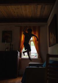 Man standing by window at home