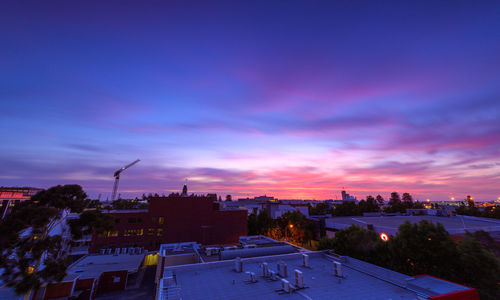 High angle view of buildings against blue sky at sunset