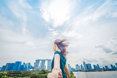 Woman with umbrella against sky