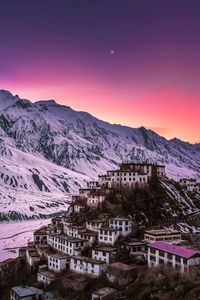 High angle view of houses and mountains against sky during sunset