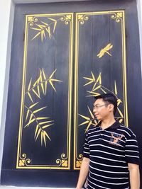 Portrait of woman standing against wall