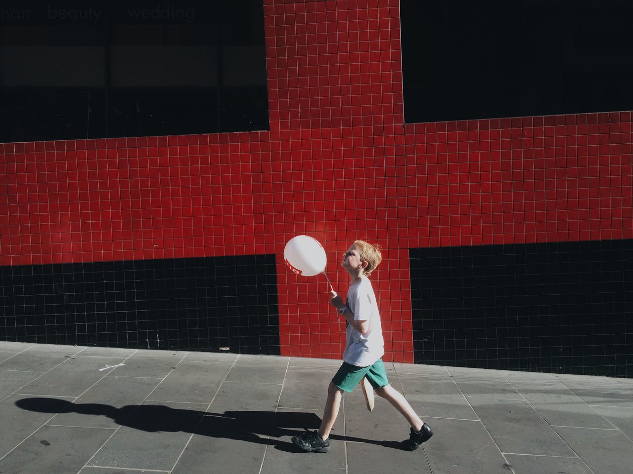 full length, red, street, lifestyles, building exterior, architecture, leisure activity, built structure, casual clothing, standing, side view, city, sidewalk, walking, holding, wall - building feature, rear view, umbrella