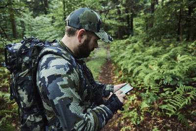 Man using mobile phone in forest