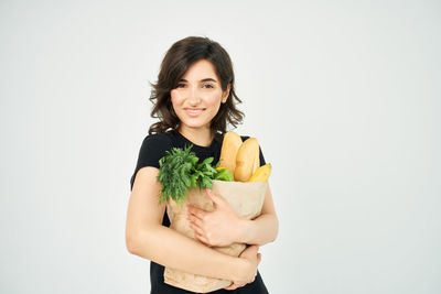 Portrait of smiling young woman against white background