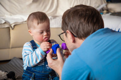 Baby boy playing with father at home