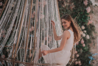 Side view of a smiling young woman standing outdoors