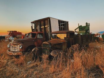 Abandoned trucks on land against sky