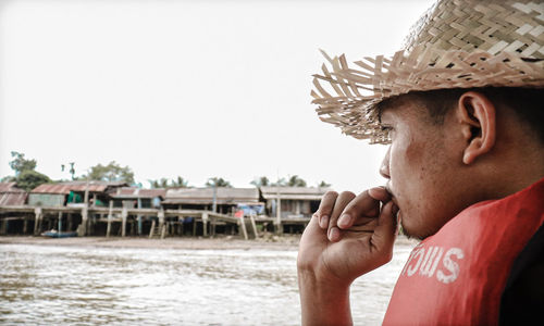 Close-up of man in hat against clear sky