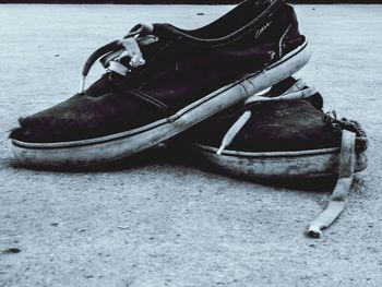 Close-up of shoes on sand