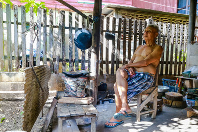 High angle view of shirtless man sitting outdoors