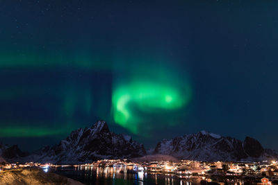 Scenic view of illuminated snowcapped mountains against sky at night