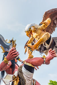 Low angle view of people in temple against sky