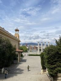 Buildings in city against cloudy sky