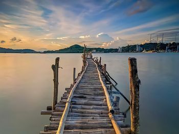 Pier over sea against sky during sunset